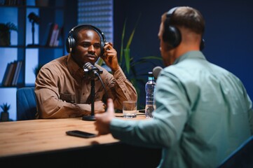 Podcasters enjoying happy conversations with online listeners in studio, covering wide range of subjects