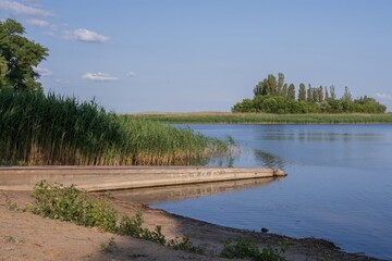 Beautiful landscape with a wide river and dense vegetation along the bank.