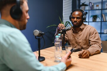 Podcast presenter having live discussion with man, streaming it for audience on internet...