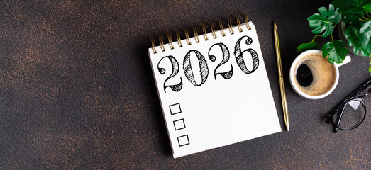 New year resolutions 2026 on desk. 2026 resolutions list with notebook, coffee cup on table. Goals, resolutions, plan, action, checklist concept. New Year 2026 template, copy space