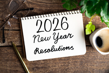 New year resolutions 2026 on desk. 2026 goals list with notebook, coffee cup, plant on wooden table. Resolutions, plan, goals, action, checklist, idea concept. New Year 2026 resolutions. Copy space