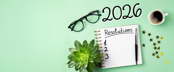 New year resolutions 2026 on desk. 2026 resolutions list with notebook, coffee cup on table. Goals, resolutions, plan, action, checklist concept. New Year 2026 template, copy space