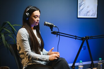 woman records podcast, speaking into microphone