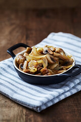 Onion with mushrooms. Rustic wooden background.	