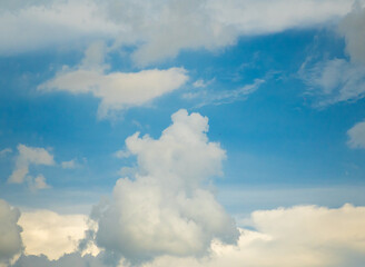 The high-resolution image shows a blue sky filled with scattered white clouds. Natural light accentuates the soft texture of the clouds.