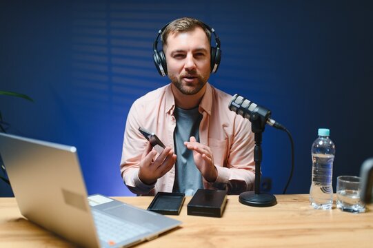 young adult man creating online content for the channel, daily vlog, unboxing a brand new phone at home, online sales