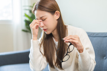 Eye care concept, fatigue asian young woman tired eyes irritated rubbing, massage nose ,eye dry...