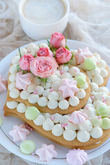 yummy sponge cake and cup of coffee on table close up. beautiful sweet treat in hearts form. delicious pastries for Valentine's day, birthday, festive date, Mother's Day, romantic party. top view