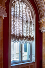 Window with arch and curtains in the palace.