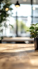 A close up shot of a wooden table with a plant and a light fixture in the background blur