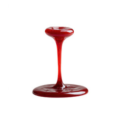 A vibrant red sauce drips elegantly from a glass holder, creating a striking visual effect against a white isolated background.