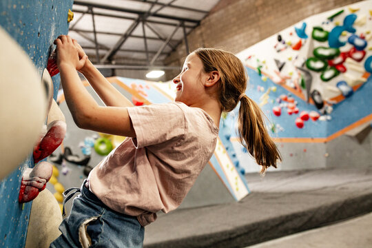 Young girl climbing the bouldering walls