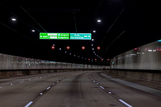 View from a car, Sydney toll road tunnel showing speed signs and four lanes