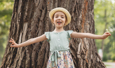 Obraz premium Funny smiling child girl 4-5 year old in park on summer season