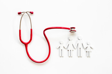 Family wooden figure with medical stethoscope - health care and insurance concept. top view