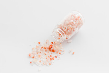 Coarse pink salt in salt shaker and spilled salt. Cooking concept