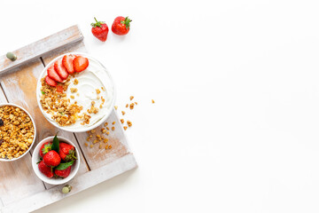 Flat lay composition with yogurt and muesli in bowl served with ingredients. Top view