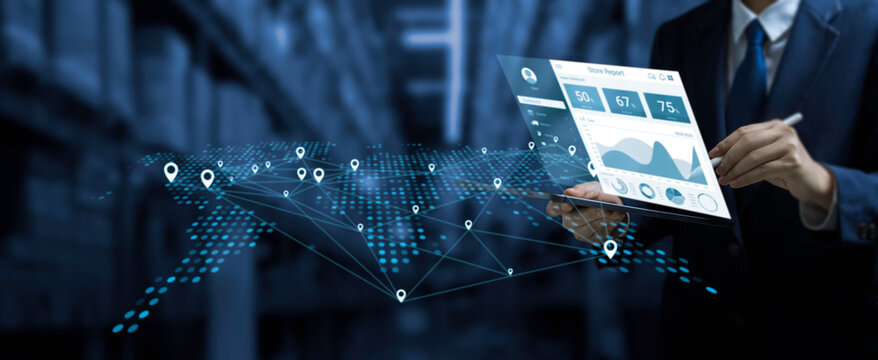 Businessman using digital tablet with real-time data analytics and GPS map network interface, illustrating smart logistics, supply chain management, and global tracking technology in a warehouse.