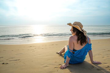 Rear view of young model observing horizon with hat on beach at Patong beach