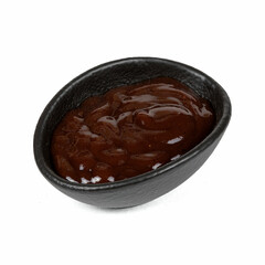 A small black bowl filled with glossy, dark brown barbecue sauce, highlighting its rich texture and savory appeal