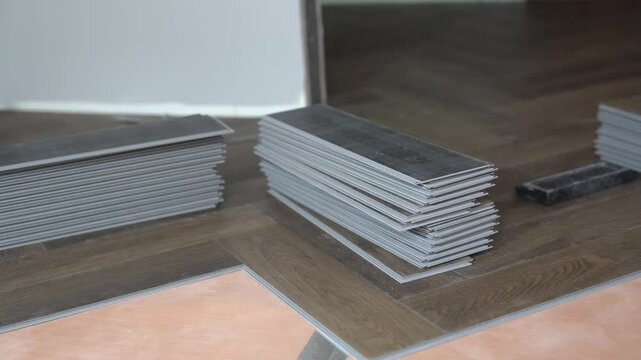 A stack of quartz vinyl flooring, laid in the shape of a herringbone. Laminate or quartz vinyl coating with wood pattern. High quality 4k footage