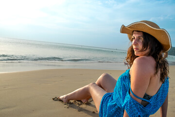 Rear view of young model observing horizon with hat on beach at Patong beach