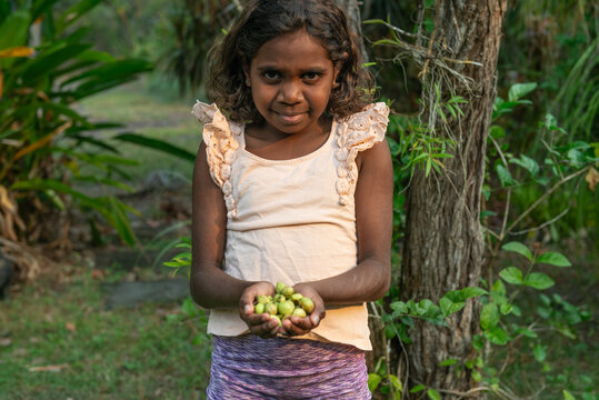 Aboriginal child holding Kakadu Plums