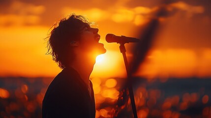 Man singing at sunset on stage with ocean backdrop