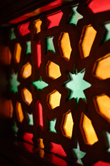Window with Arabic colored lattice, soft curtain dropped on side and dim light