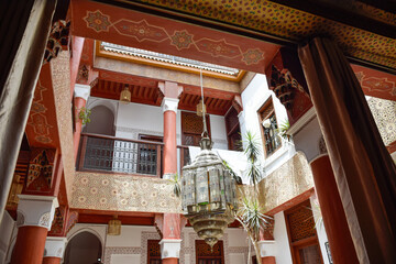 Typical Inner Courtyard Marrakech with red columns and a large colored lamp