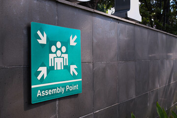 Emergency Assembly Point Sign on a Gray Wall – Safety and Evacuation Concept