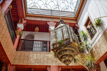Typical Inner Courtyard Marrakech with red columns and a large colored lamp