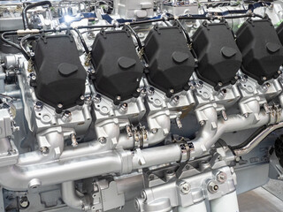 Powerful multi-cylinder internal combustion engine with visible valve covers and intake manifold,...
