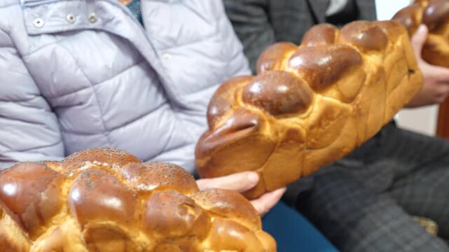People hold traditional bread in their hands to bless the bride and groom.