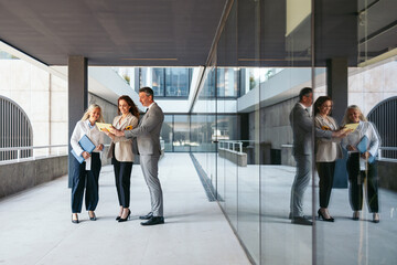Business team discussing contract details outside modern office building