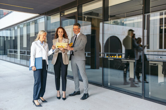 Businesspeople reviewing contract terms outside modern office building