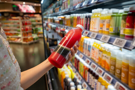 Young women buying juice at supermarkets