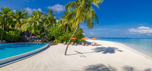 Inspire tropical beach resort pool palm trees chairs umbrellas leisure tourism sunny blue sky. Stunning sea view beach landscape. Summer vacation amazing coastal relaxation. Closeup sunshine sand wave
