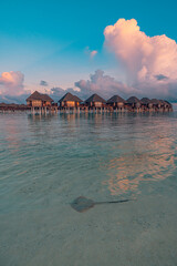 Stunning Maldives water villas sunset breathtaking sea bay view. Amazing summer landscape luxury travel vibes. Tranquil picturesque beach tourism romantic tropical escape. Couple honeymoon destination