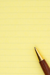 Yellow ruled legal pad paper with pen background