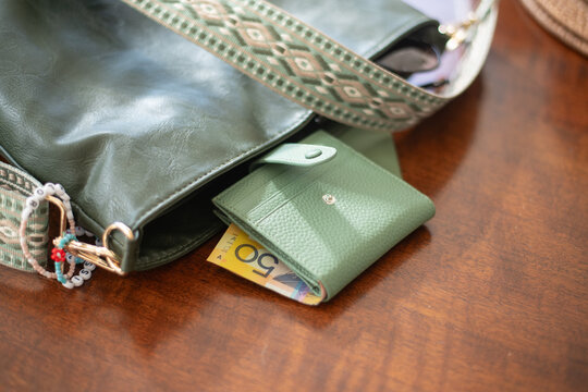 green wallet and green handbag with Australian money.