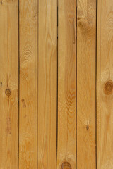 Rough-cut wooden boards. Barrier fence made of unplaned boards.