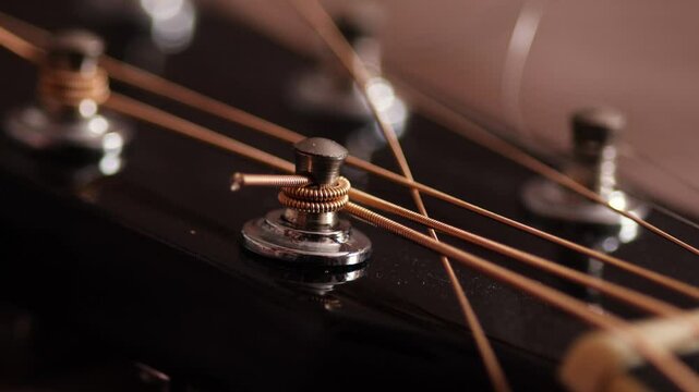 close-up installing new strings on a guitar, replacing old strings, close-up using nippers to cut off excess length of new strings
