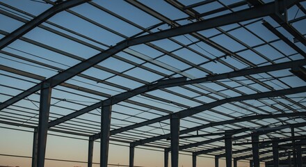 Steel framework of a building under construction against a twilight sky
