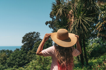 Woman with Straw Hat Looking at Lush Forest