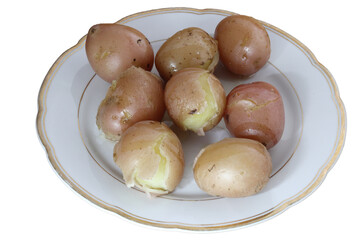 Boiled unpeeled potatoes on a porcelain plate.