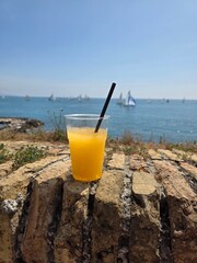 summer frozen cocktail, yellow with melon wootz on the background of nature, sea yachts,