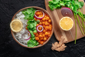 Chana masala, chickpea curry, traditional Indian dish, overhead flat lay shot with fresh ingredients on a black background