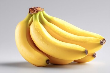 Ripe yellow bananas forming a bunch are covered with tiny water droplets, creating a fresh and appealing look against a simple gray backdrop