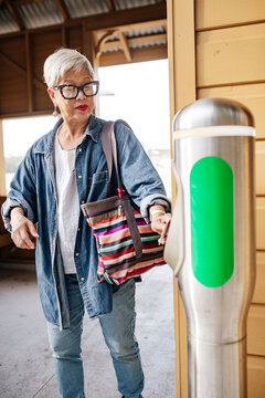 Senior Asian woman scanning her concession travel card on tap on device
